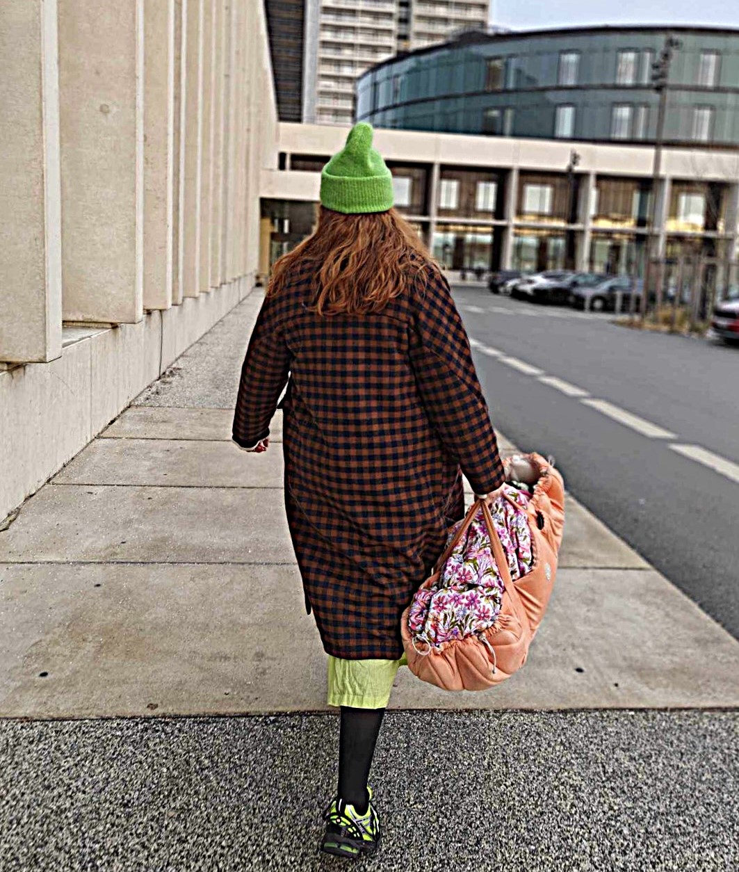 Kvinde går med ryggen til, mens hun holder en babylift