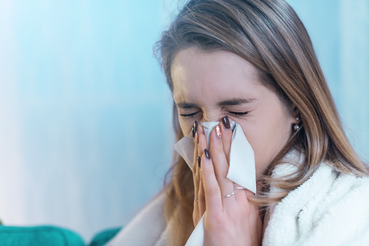 Kvinde nyser i lommetærklæde