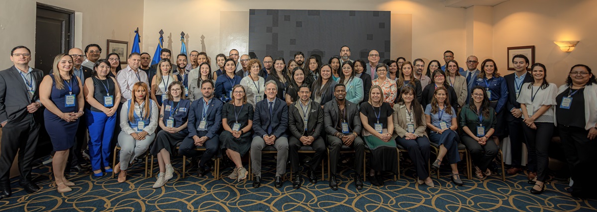 Gruppefoto af mange mennesker opstillet i et rum