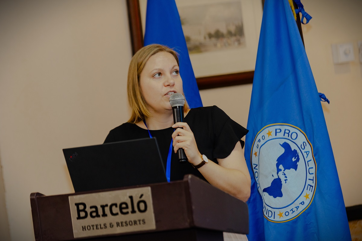 Kvinde med en mikrofon står på en talerstol