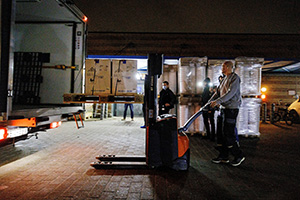 Gaffeltruck tager vacciner ud af bil
