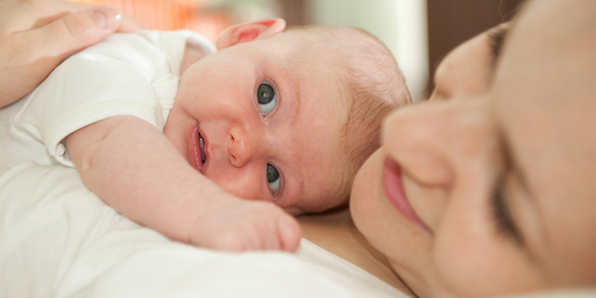 Baby ligger på mor